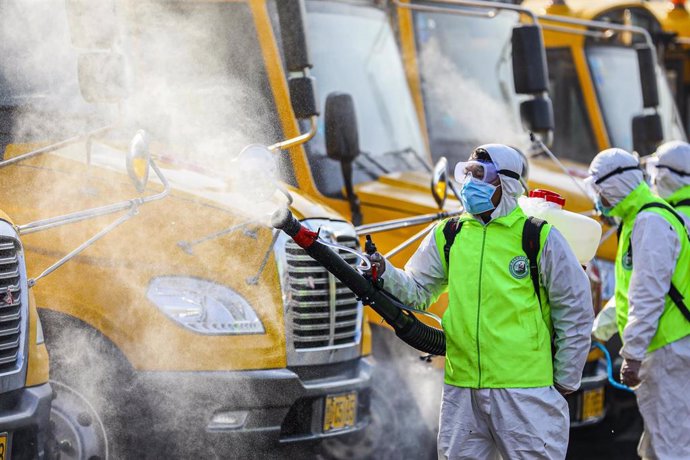 Imagen de archivo de trabajadores desinfectando camiones.