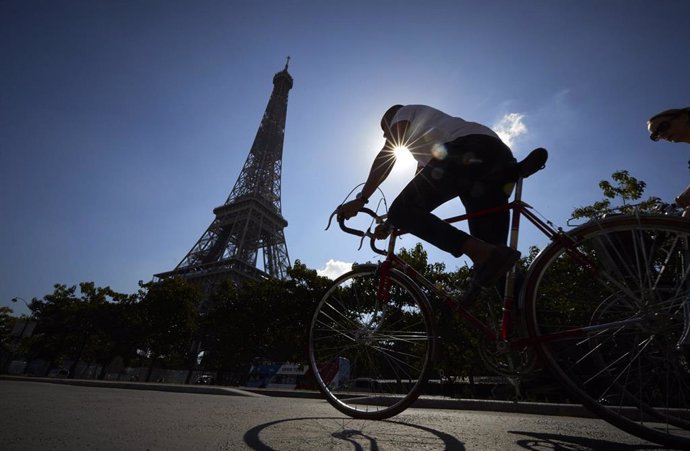 Un ciclista pasa ante la Torre Eiffel en París