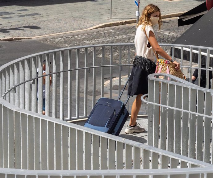 Una joven turista con maletas en el entorno de las Setas de la Encarnación, en  Sevilla a 3 de agosto del 2020