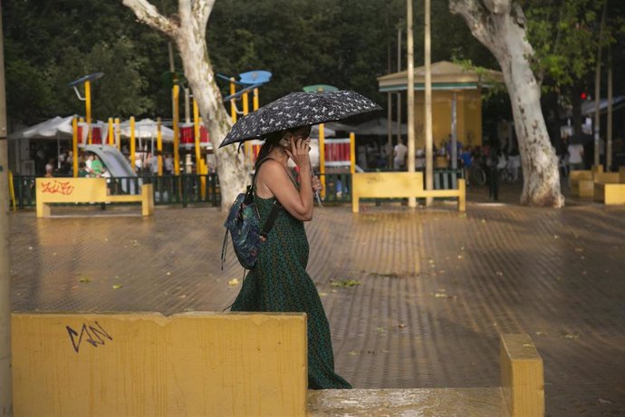 Una mujer camina bajo paragüas ante la lluvia, en una imagen de archivo.