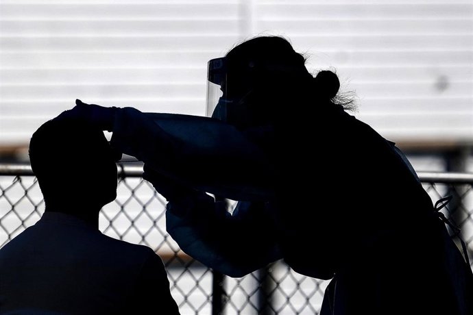 Personal médico toma muestras para realizar una prueba de la COVID-19 en un una unidad móvil desplegada en la bahía de Rushcutters, en Sidney, Australia.