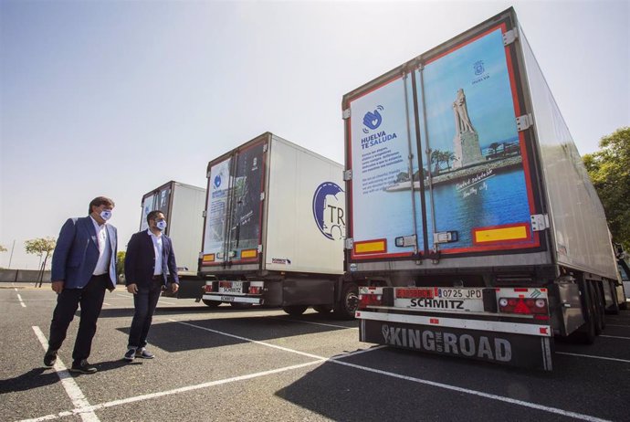 El alcalde supervisa los camiones con la imagen de Huelva. 