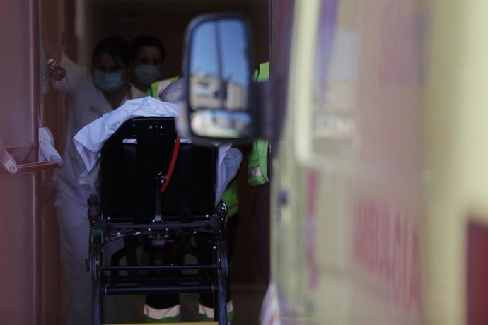 Personal sanitario ante una ambulancia con un paciente, en una imagen de archivo.