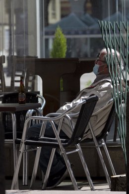 Un hombre de edad avanzada en una terraza de la capital de A Coruña, el día que en el que la provincia pasa junto al resto de las que componen Galicia -Pontevedra, A Coruña y Ourense- a la Fase 1 del Plan de Desescalada establecido por el Gobierno de Es