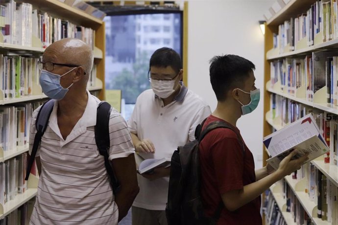 Ciudadanos con el buen hábito de leer ojean posibles joyas literarias en una librería pública de Hong Kong.