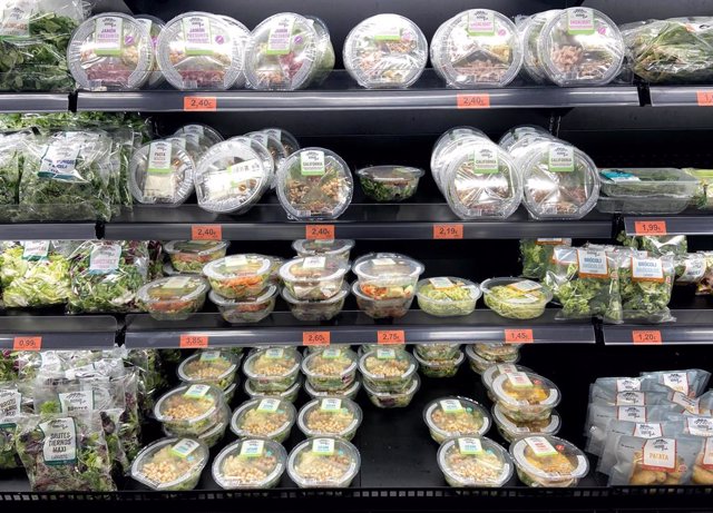 Neveras con packs de ensaladas en la sección de frutas y verduras de  un supermercado.