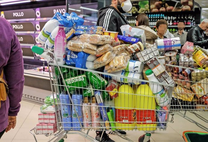 Un cliente realiza la compra en un supermercado un día marcado por colas de gente al inicio de la pandemia.