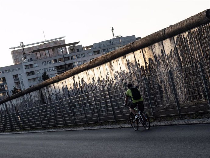 Un ciclista junto a los restos del Muro de Berlín