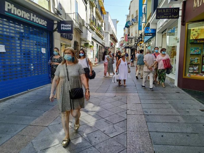 Personas con mascarilla en la calle Santa Eulalia de Mérida