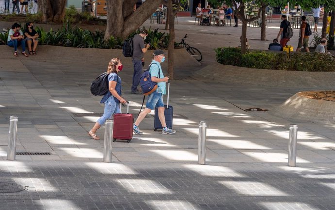 Dos turistas con maletas  en el entorno de las Setas de la Encarnación, en  Sevilla a 3 de agosto del 2020