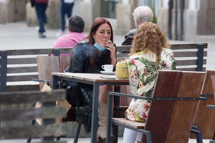 Una persona fuma en una terrassa durant el primer dia de la prohibició de fer-ho en la via pública a Galícia si no existeix una distncia de dos metres de separació amb altres persones per evitar contagis de Covid-19, a Lugo ,a 13 d'agost de 2020.