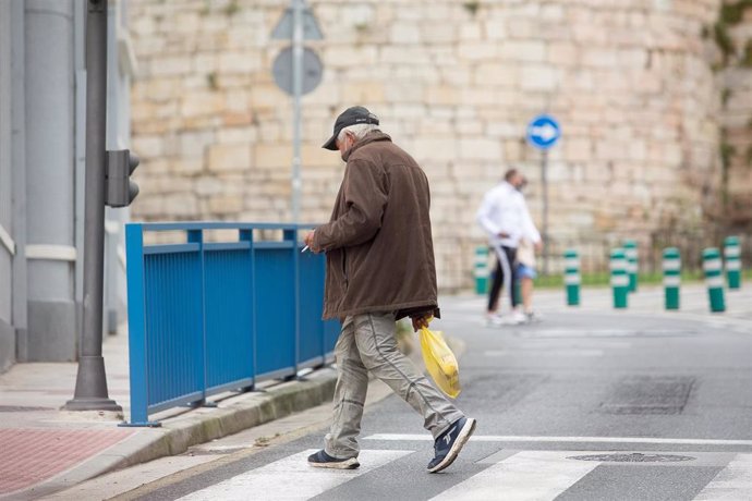 Una persona fuma durante el primer día de la prohibición de realizarlo en la vía pública en Galicia si no existe una distancia de dos metros de separación con otras personas para evitar contagios de Covid-19, en Lugo, a 13 de agosto de 2020.