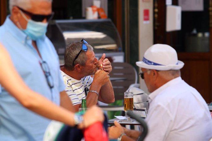 Personas fumando en terrazas y vías públicas  durante el día en el que se ha decretado la prohibición de fumar en espacios públicos si no se respeta la distancia de seguridad establecida. Málaga a 14 de agosto del 2020