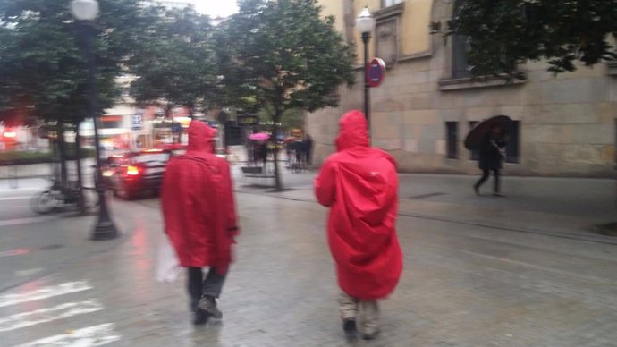 Turistas en Gijón, bajo la lluvia