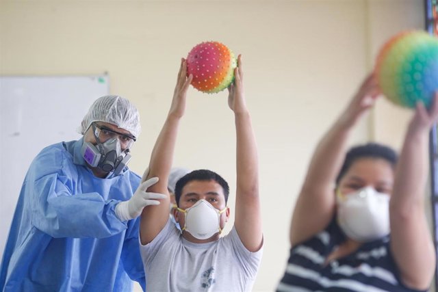 Un trabajador sanitario trabajando en una clínica de rehabilitación con un traje protector por el coronavirus.