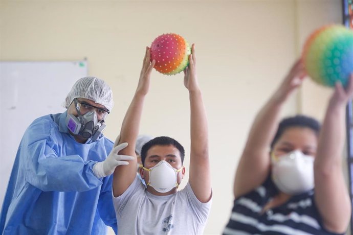 Un trabajador sanitario trabajando en una clínica de rehabilitación con un traje protector por el coronavirus. 