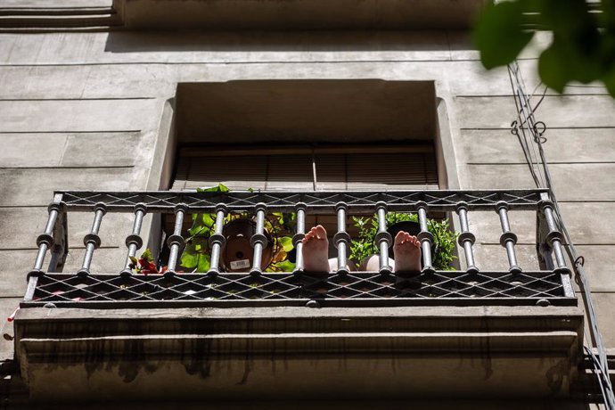 Una persona pren el sol en la seva balconada durant el confinament a Barcelona