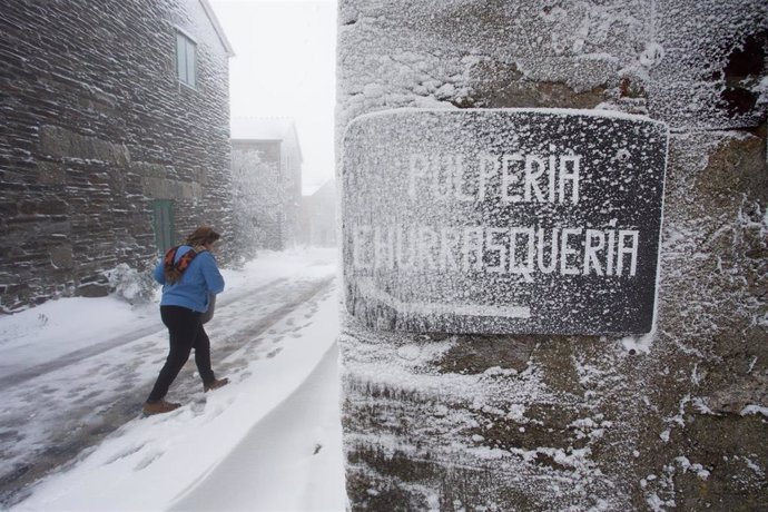Una vecina de la localidad camina entre la nieve por las callejuelas del municipio de Pedrafita do Cebreiro, en Lugo-País Vasco (España), a 17 de diciembre de 2019.