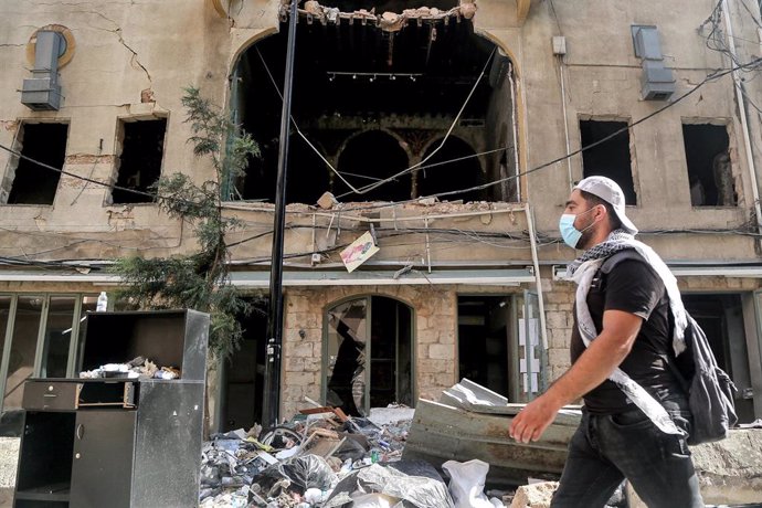 Un hombre con macarilla delante de un edificio afectado por las explosiones en Beirut