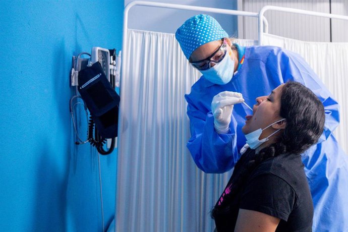 Un trabajador sanitario protegido le realiza a una mujer un test PCR en el Centro de Especialidades  