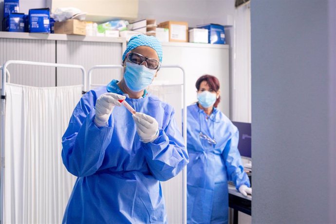 Un trabajador sanitario protegido sostiene una de las probetas utilizadas para la realización de tests PCR en el Centro de Especialidades Carabanchel Alto 