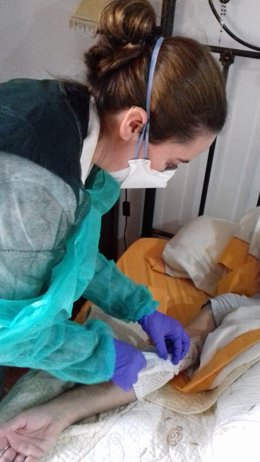 Una profesional administra el tratamiento al paciente en su domicilio.
