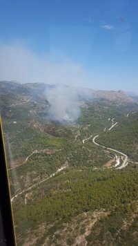 Medios aéreos y terrestres trabajan en la extinción de un incendio en la Vall de Laguar (Alicante)