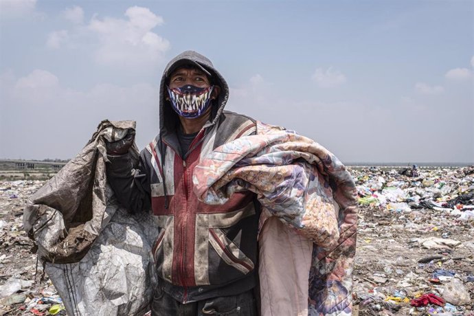 Un recolector de basura ataviado con una mascarilla mientras trabaja en uno de los grandes vertederos de Ciudad de México.