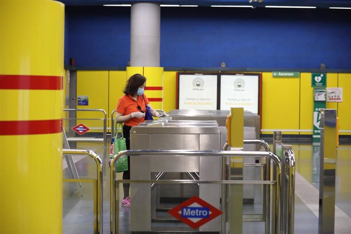 Una mujer protegida con mascarilla hace uso del Metro de Madrid, a 22 de mayo de 2020.