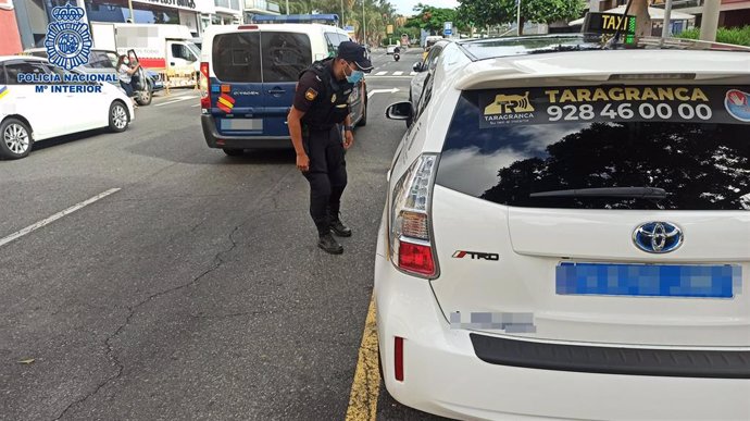 Agente de la Policía Nacional habla con un taxista