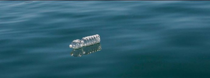 Imagen de una botella de plástico en el mar