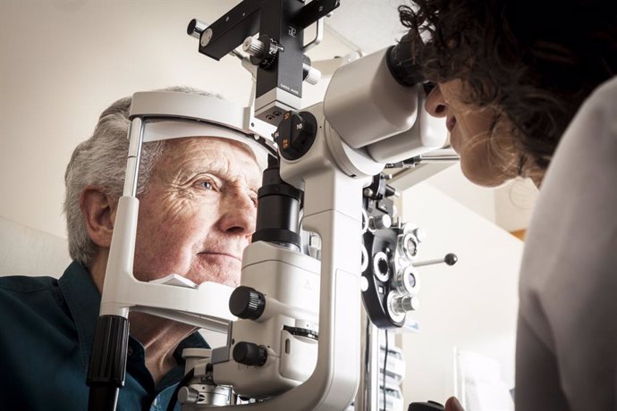 Óptico-Optometrista revisando la vista a un paciente mayor.