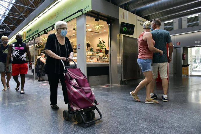 Varios clientes realizan compras en el Mercado de Sant Anton (Barcelona)