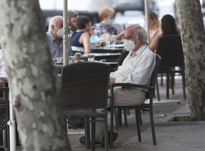 Varias personas disfrutan en una terraza el día en el que el INE ha publicado que el Índice de Precios de Consumo (IPC) bajó un 0,9% en julio en relación al mes anterior y recortó tres décimas su tasa interanual, hasta el -0,6%, frente al -0,3% de junio
