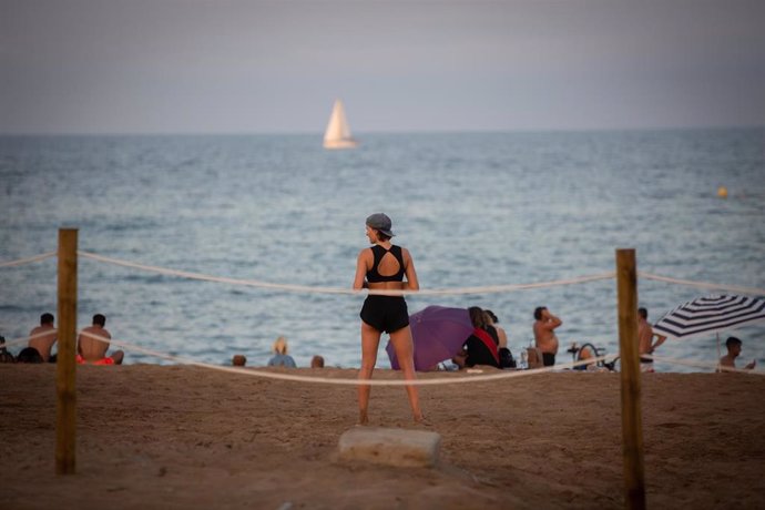 Una bañistas, de espaldas a la cámara, en la playa en Barcelona, Catalunya (España), a 28 de julio de 2020. 