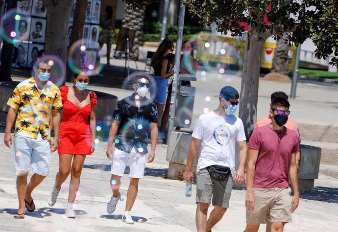Turistas paseando con mascarilla por Palma.
