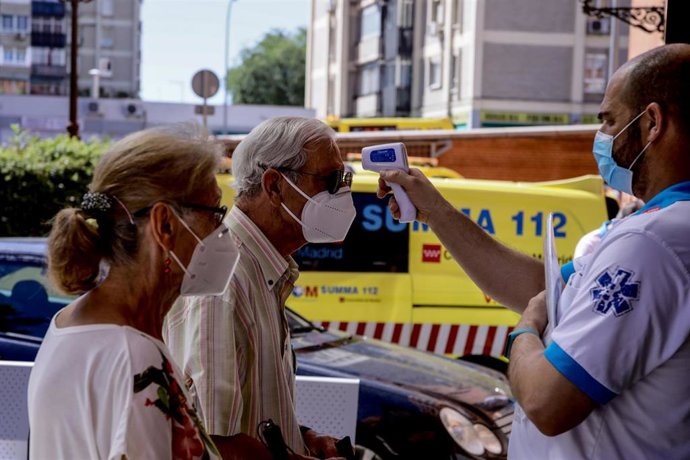 Un trabajador sanitario toma la temperatura a un hombre protegido con mascarilla donde durante la jornada de hoy realizarán PCR aleatorias a personas de entre 15 a 49 años.