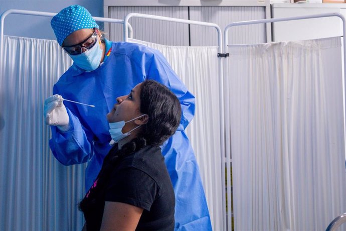 Un trabajador sanitario protegido le realiza a una mujer un test PCR en el Centro de Especialidades