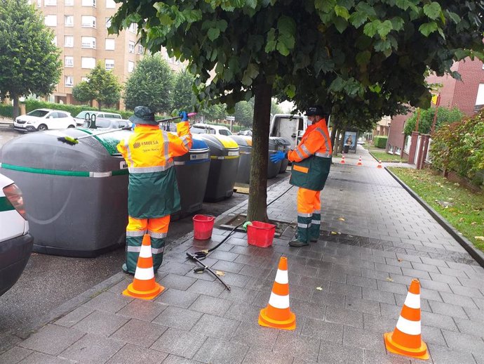 Unos operarios de Emulsa limpian una estación de contenedores en el barrio de Montevil, en Gijón