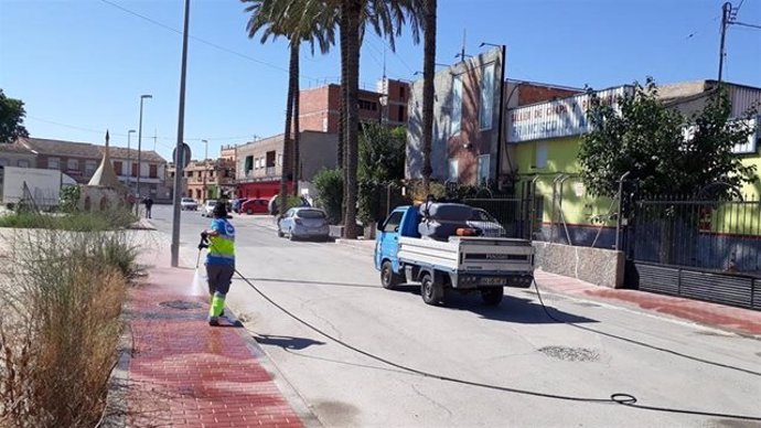 Operarios del servicio de limpieza del Ayuntamiento de Murcia desinfectan el entorno del local donde se celebró el pasado sábado una boda tras detectarse cuatro positivos en covid-19 entre los invitados