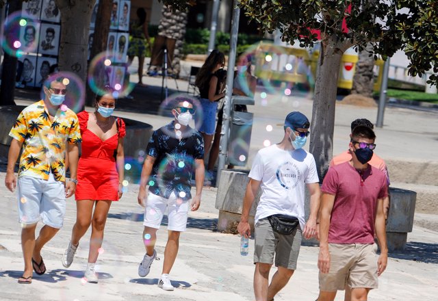 Varias personas con mascarilla pasean por Palma.