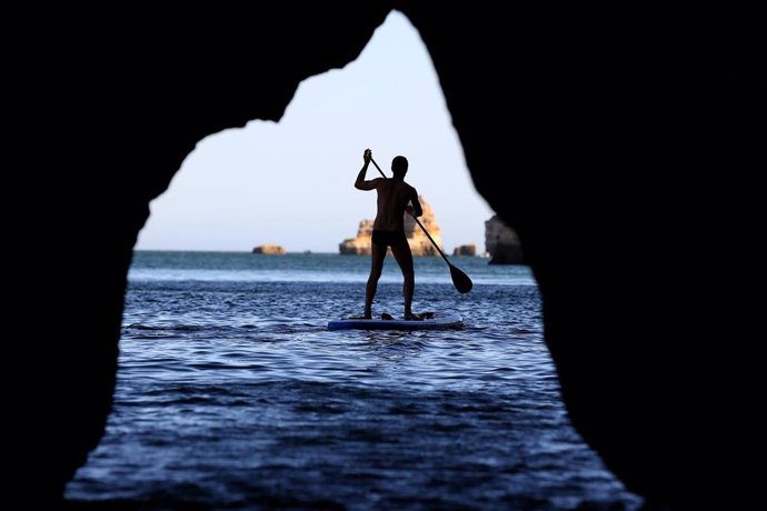 Un hombre hace paddle surf en Lagos, en la región del Algarve