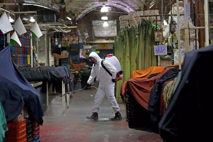 Un trabajador sanitario desinfecta el mercado de La Merced en México. 