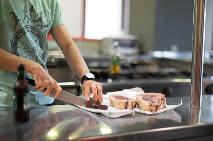 Un camarero corta carne 