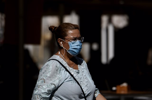 Una mujer camina con mascarilla el día en el que entra en vigor en la Comunidad de Madrid la ampliación del uso obligatorio de la mascarilla,,