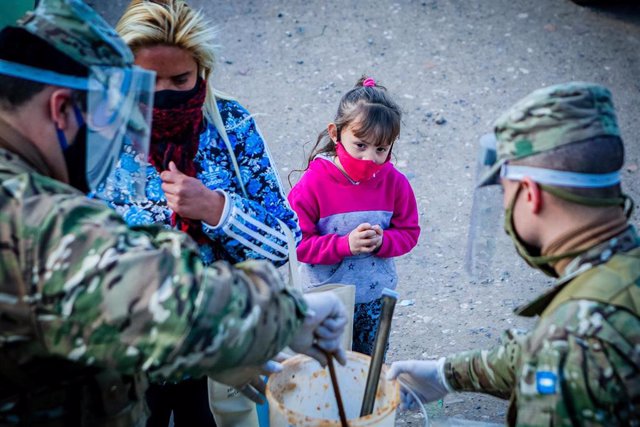 Niña con mascarilla junto a militares en Buenos Aires, Argentina