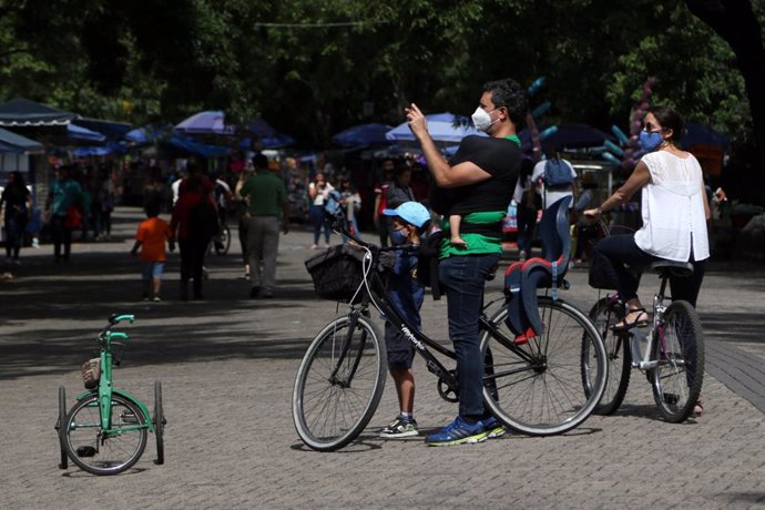 Una familia pasea en bicicleta por el bosque de Chapultepec, un parque urbano si