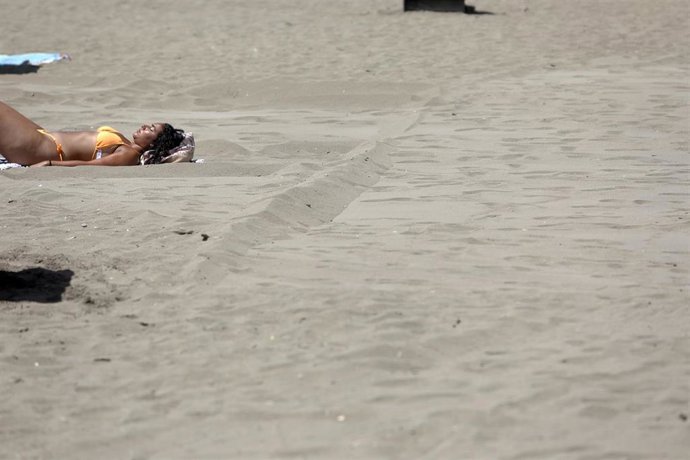 Una mujer tomando el sol en la playa de La Malagueta, foto de archivo