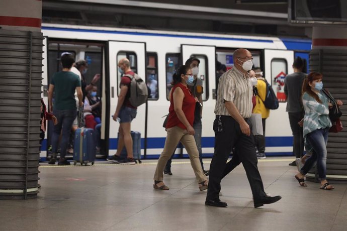 Pasajeros con mascarilla salen de un vagón en la estación de Metro de Atocha, en Madrid (España), a 22 de junio de 2020.