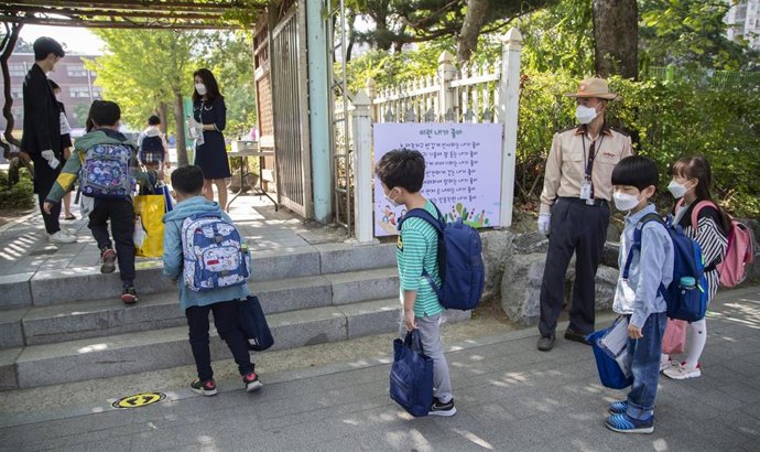 Un grupo de pequeños estudiantes retoman las clases en un escuela de Seúl, después de que las autoridades del país relajaran algunas de las medidas de prevención contra el COVID-19.